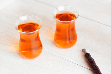 Traditional Turkish cups of tea on the wooden background.
