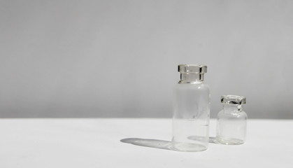 Small glass empty jars on a white table. Place for text. Front view.