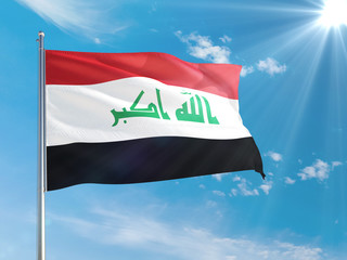 Naklejka na ściany i meble Iraq national flag waving in the wind against deep blue sky. High quality fabric. International relations concept.