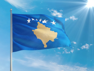Kosovo national flag waving in the wind against deep blue sky. High quality fabric. International relations concept.