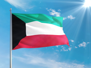 Kuwait national flag waving in the wind against deep blue sky. High quality fabric. International relations concept.