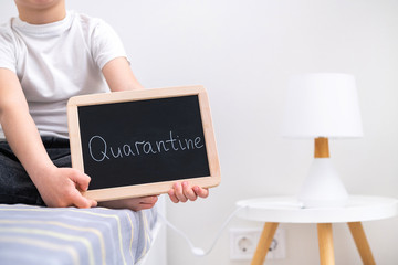 The child is quarantined in his room. Quarantine sign in hand