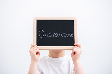 The child holds a quarantine nameplate inscription in his hands