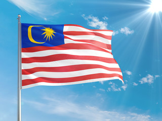 Malaysia national flag waving in the wind against deep blue sky. High quality fabric. International relations concept.