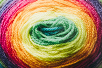 Close up sur une pelote de laine couleur arc en ciel