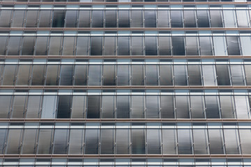 Symmetrically background of gray sunshades facade modern office building