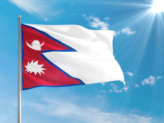 Nepal national flag waving in the wind against deep blue sky. High quality fabric. International relations concept.
