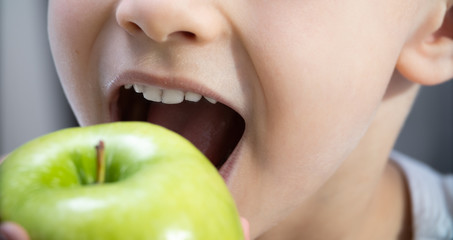 children's teeth bite a green Apple. healthy teeth and care