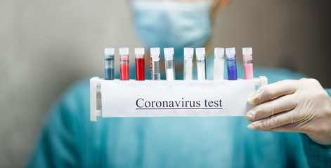 male doctor laboratory assistant is holding in his hands a medical test tube with a coronavirus test.