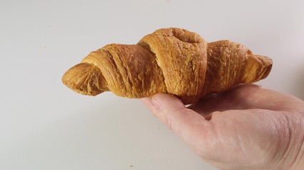 Croissants with butter and knife on white kitchen table. Close up.