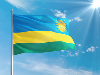 Rwanda national flag waving in the wind against deep blue sky. High quality fabric. International relations concept.
