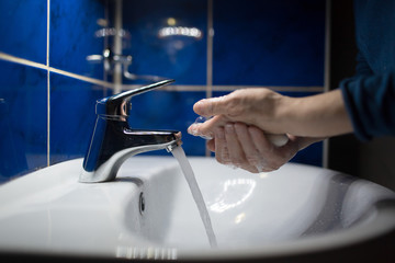 Woman washes hands with soap under water tap. Coronavirus prevention and washing. Pandemic COVID-19 Hygiene Rules.
