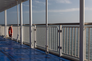 Gate and ring life preserver on a ferry ship exterior walkway, horizontal aspect
