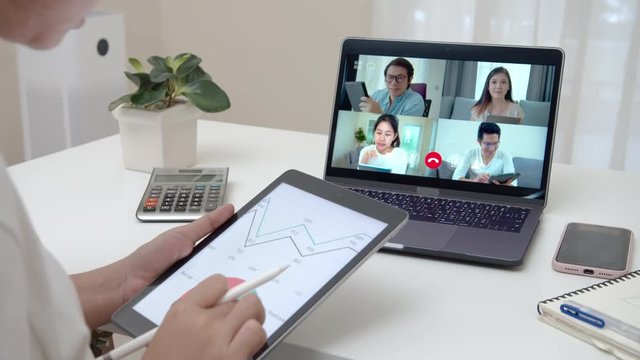 Zoom out of business woman talking about sale report in video conference. Asian team using laptop and tablet online meeting in video call.Working from home, Working remotely and Social isolation.
