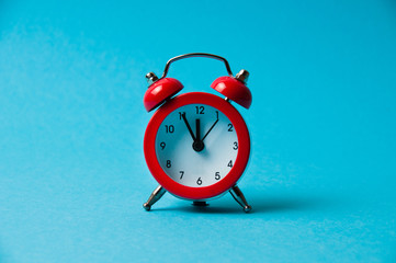 Vintage alarm clock red on blue background