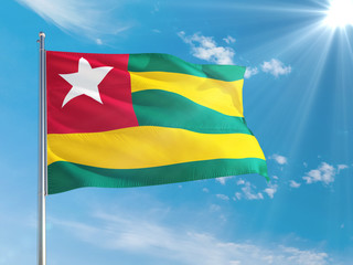 Togo national flag waving in the wind against deep blue sky. High quality fabric. International relations concept.