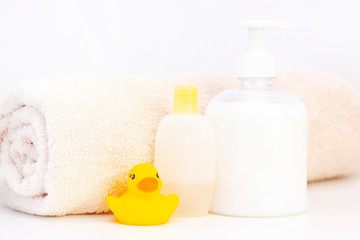Obraz na płótnie Canvas baby hygiene and bath items, shampoo bottle, baby soap, towel, yellow duck rubber toy