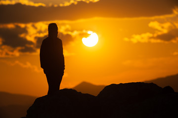silhouette of a man standing on the top of mountain