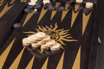 Backgammon. Board game. White cubes and chips on a blackboard.  Dice on backgammon board game. Selective focus. Playing leisure games