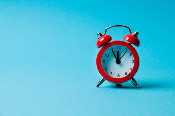 Vintage alarm clock red on blue background