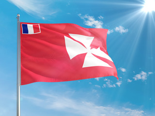 Wallis And Futuna national flag waving in the wind against deep blue sky. High quality fabric. International relations concept.