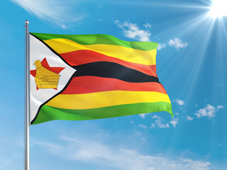 Zimbabwe national flag waving in the wind against deep blue sky. High quality fabric. International relations concept.