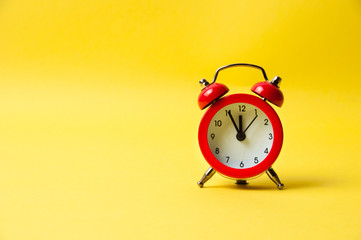 Vintage alarm clock red on a yellow background