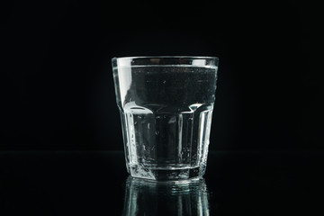 Purified fresh water in glass on mirror background