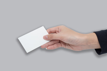 Obraz premium A women hand holding a white card for business on gray background with clipping path