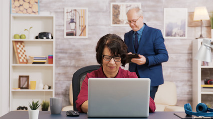 Amazed old woman after reading a news on laptop