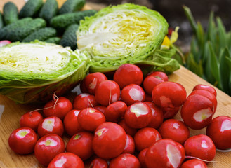 Harvest. Vegetables from the garden. Cucumbers, radishes, tomatoes and cabbage. Veganism and raw food diet, healthy vegetables for salad.