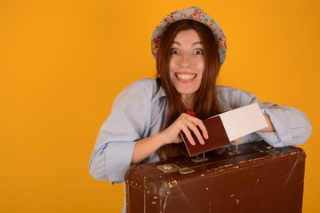 woman in cap smiling with passport tickets old suitcase on trip blue background