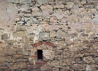 Alte beschädigte Mauer mit kleiner Luke