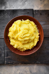 Mashed potatoes in a bowl. Dark background, top view, place for text.