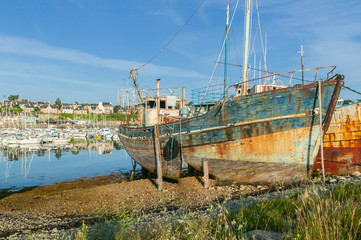 Fototapeta na wymiar rotten fishing vessels on the beach of the pitouresk breton village of Camaret sur mer