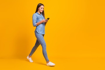 Full size profile side photo cheerful lovely pretty girl enjoy spring holiday use smartphone follow social network news wear good look shirt gumshoes isolated bright shine color background