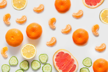 Fruits and vegetables on a white background, including citrus lemon and tangerines, grapefruit and fresh sliced cucumber. concept vitamins, healthy food, backgrounds for grocery stores.