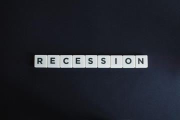 Word Recession made up of block letters on black background. Concept of global economic crisis.