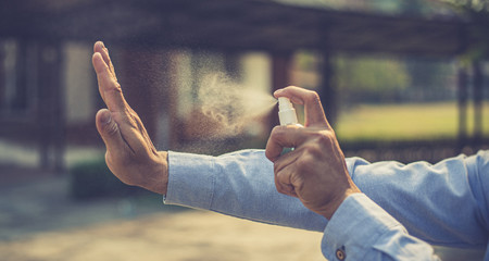 Young men use 70% alcohol spray to eliminate bacteria and viruses CORONA Or influenza COVID-19,...