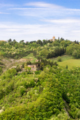 Fototapeta na wymiar Nice landscape view of therural lands Umbria in central Italy with an old fortress perched on the peak of a green hill, a medieval castle become a tourist attraction surrounded by trees and nature
