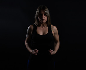 Muscled fitness athlete woman on black background
