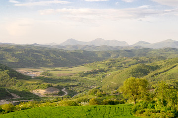 Fototapeta premium Amazing green landscape in central Italy, in Umbria between Gubbio and Assisi. Here the land is highly cultivated and there are a lot of beautiful old trees and many footpaths to walk in the nature