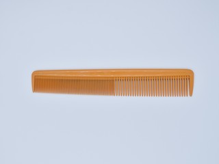 Yellow comb on white background 