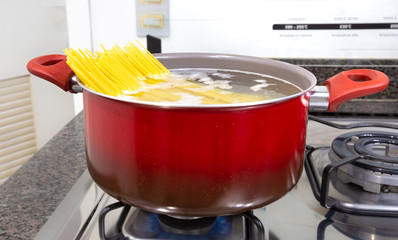 Spaghetti being cooked in a red pan