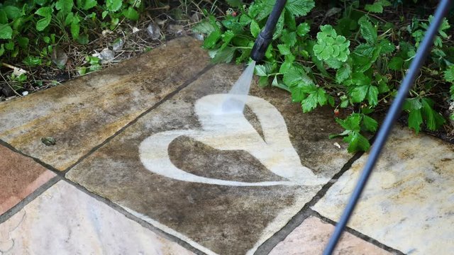 Mit Wasser aus einem Hochdruckreiniger ein Herz auf die Terrasse malen