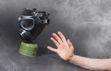 Man in room filled with smoke, trying to reach for vintage gasmask - Green filter