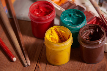 Master at work drawing made with gouache paints, still life. Paint cans and brushes hand of the...