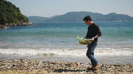 Environmental activist collecting plastic on a beach clean up due to climate emergency and ocean destruction, Hong Kong