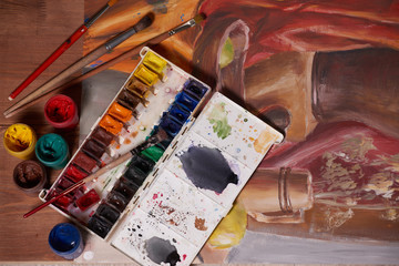 Master at work drawing made with gouache paints, still life. Paint cans and brushes hand of the...