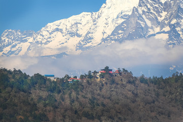 View of Tengboche village with Thyangboche Monastery, also known as Dawa Choling Gompa, from far away. Taboche mountain and clouds in the background. Theme of travel in Nepal. - obrazy, fototapety, plakaty